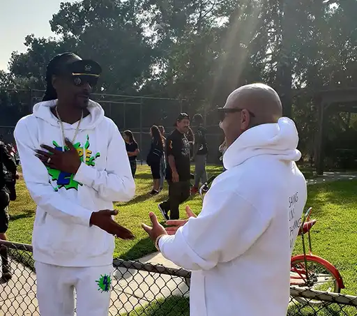 Karim Gharbi talking with Snoop Dogg outdoors